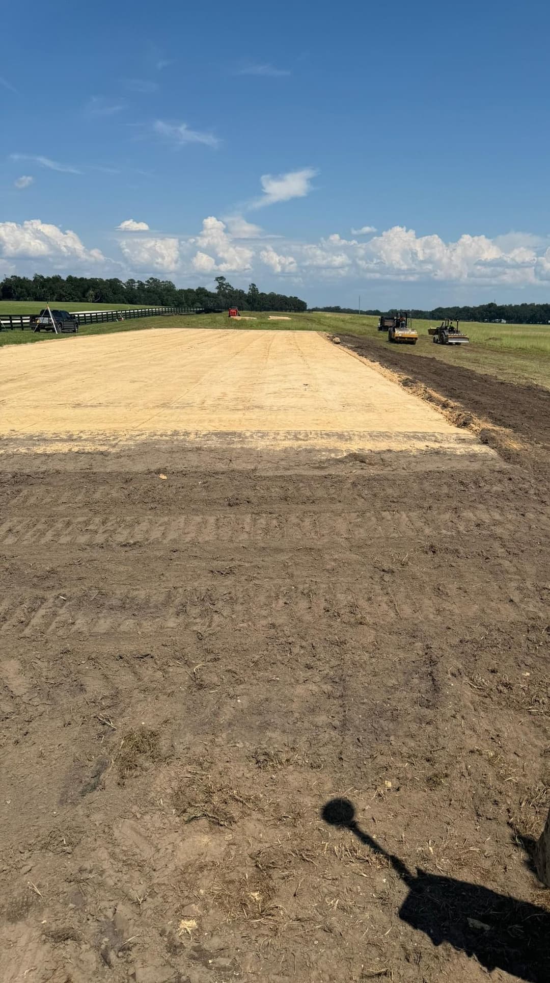 Cleared agricultural field under blue sky, preparation for planting in rural landscape.