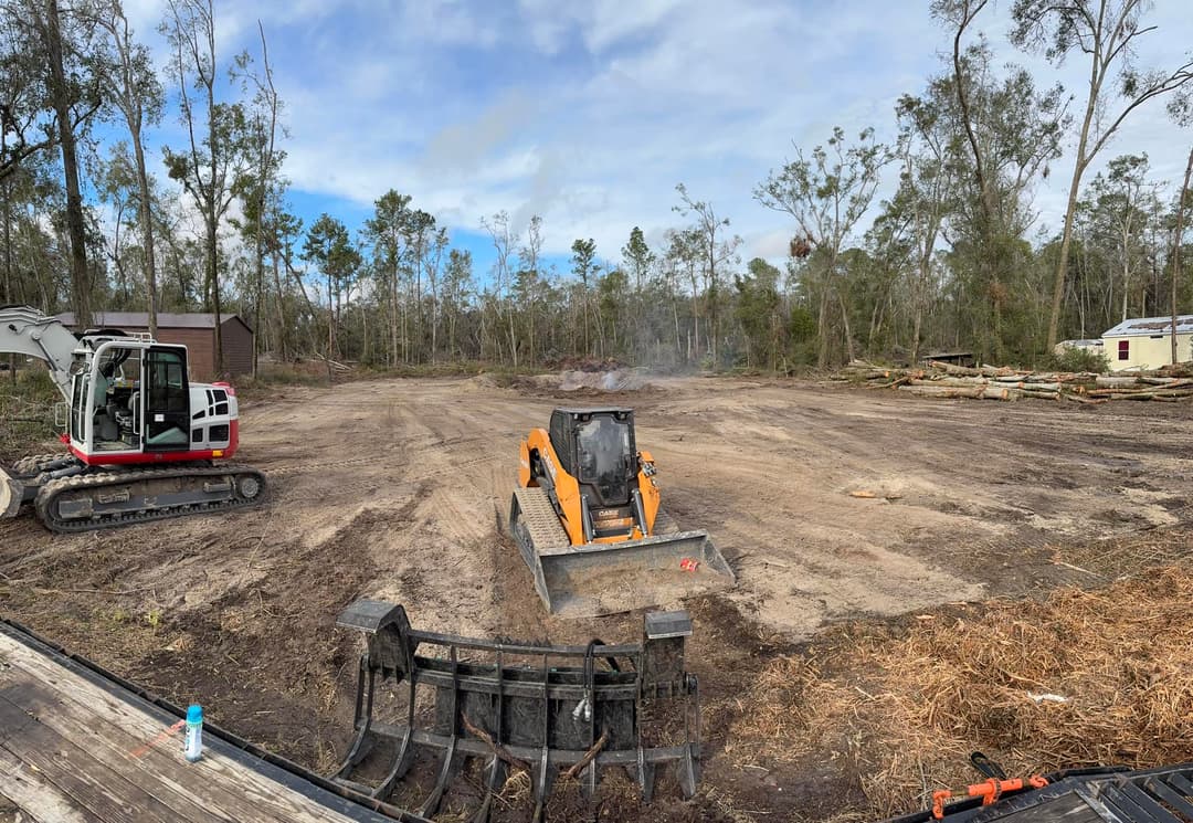 Cleared land with construction equipment, showcasing deforested area and machinery in use.