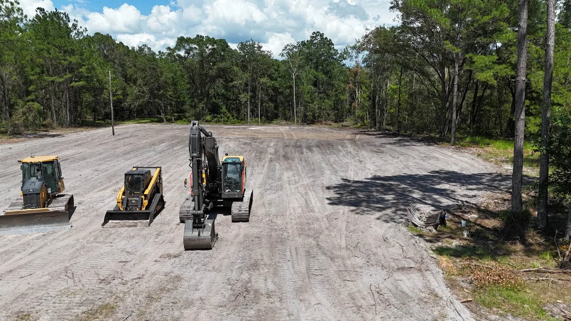 Aerial three machines cleared sandy pad bulldozer loader excavator alachua suwan