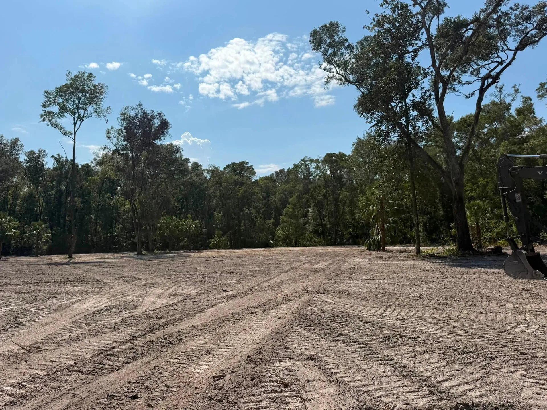Cleared sandy lot excavator bucket lake city FL